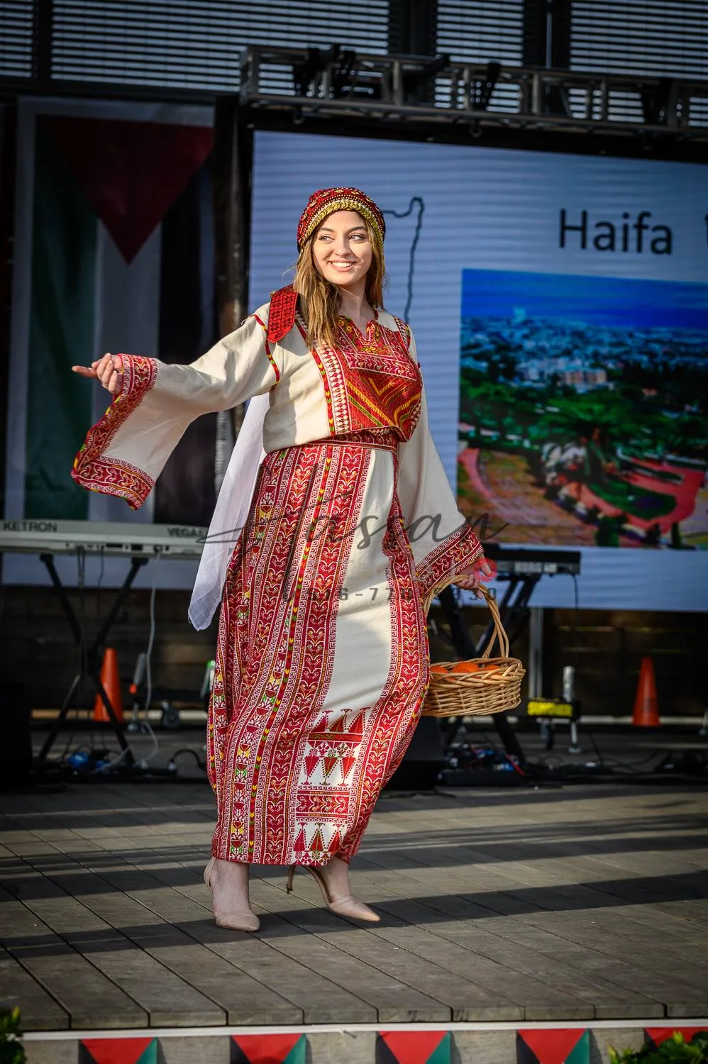 Woman presenting a Haifa dress with red Palestinian embroidery at the 2019 festival