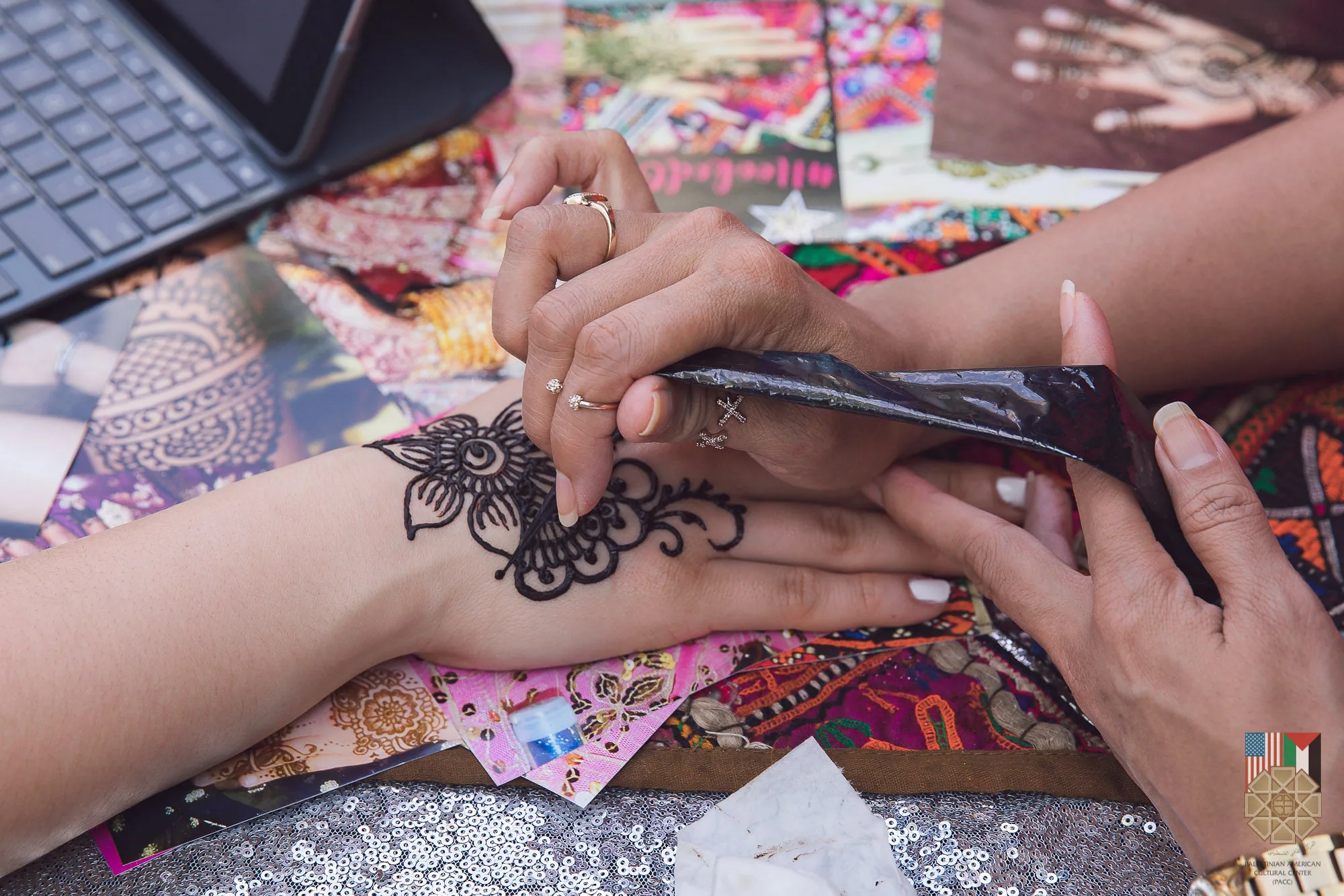 A henna artist decorating a visitor's hand at the 2019 Houston Palestinian Festival