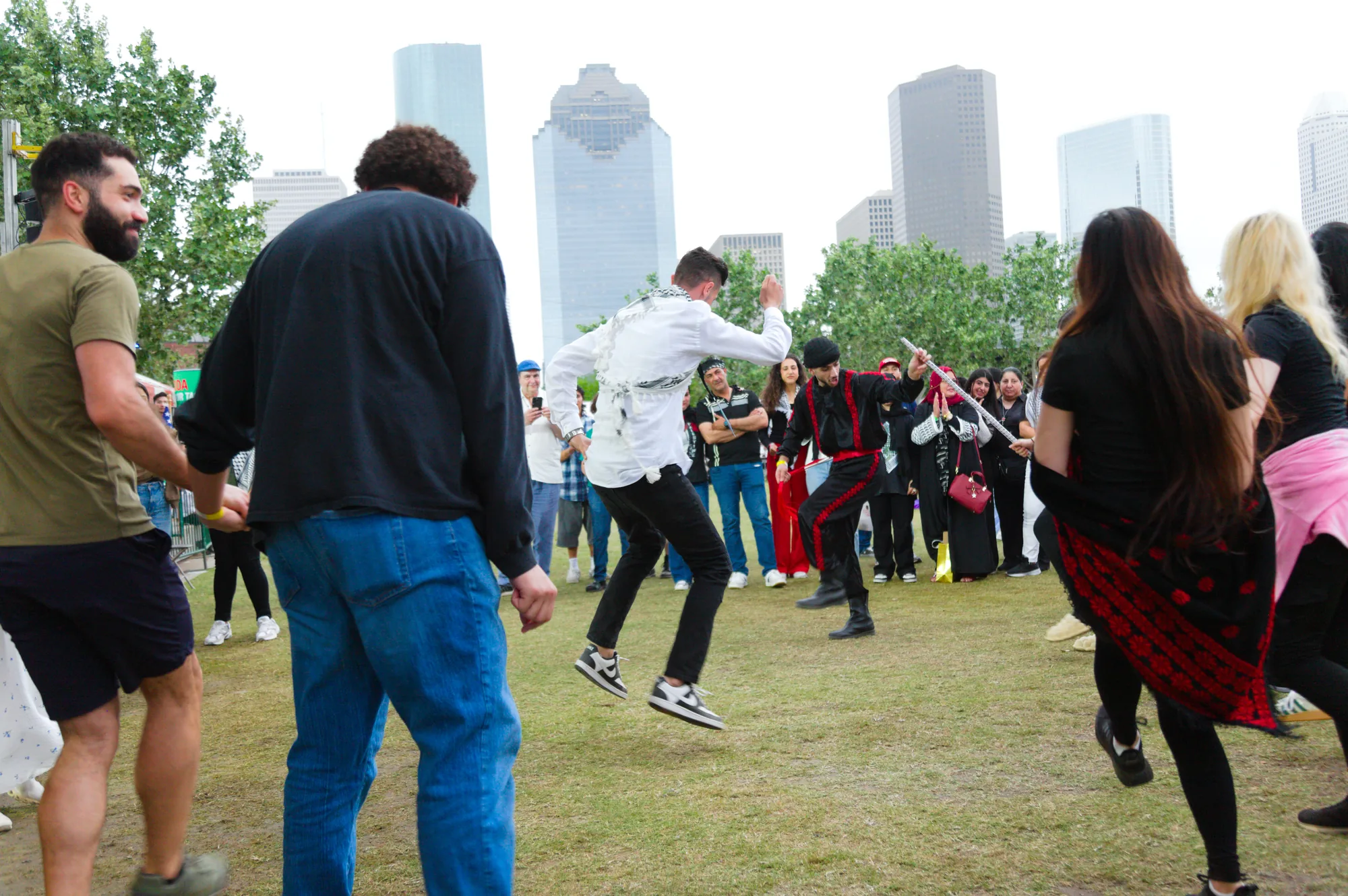 Dabke dancers and festival visitors gathered with the Houston skyline behind them