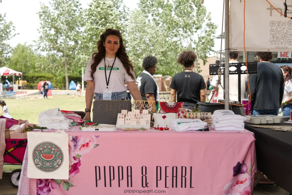 A Festival vendor displaying Palestinian clothing, jewelry, and artwork