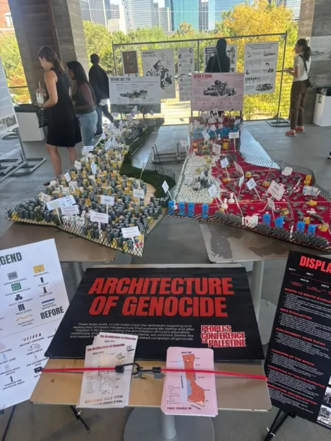 A museum exhibit with miniature buildings, maps and informational panels.